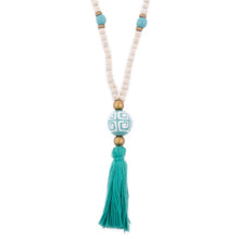 Load image into Gallery viewer, Natural wood bead necklace with turquoise tassel featuring a large ceramic bead in the center