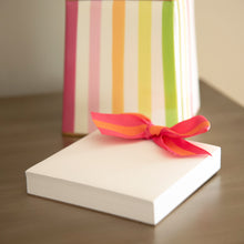Load image into Gallery viewer, Lifestyle image of the orange and pink canvas ribbon notepad
